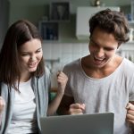Excited Couple Ecstatic By Online Win Looking At Laptop Screen