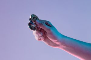 Male Hand With Golden Bitcoin On Blue Background