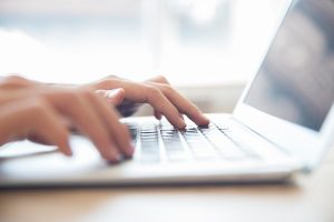 Close Up Of Male Hands Typing On Laptop Keyboard