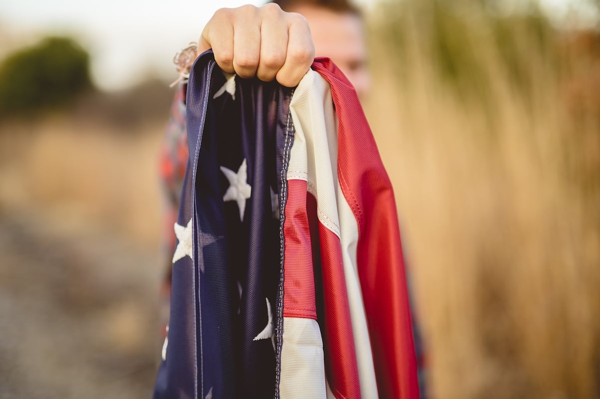 Closeup Shot Of A Male Holding The Flag Of The United States
